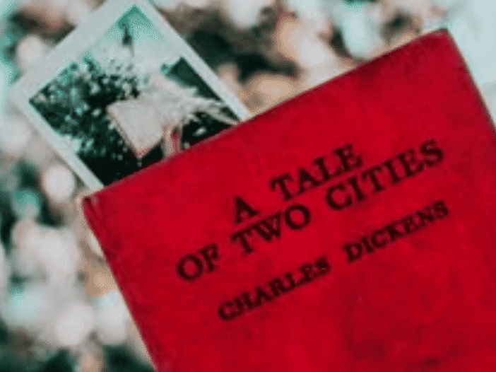 Red copy of A Tale of Two Cities by Charles Dickens with a vintage photograph tucked inside.
