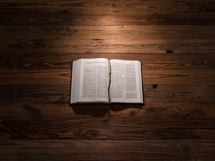 Open Bible on table symbolizing reading scripture for overcoming fear and finding courage in daily life