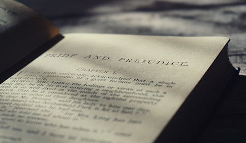 Open book showing the first chapter of Pride and Prejudice, illustrating romantic quotes from classic literature in soft natural lighting.