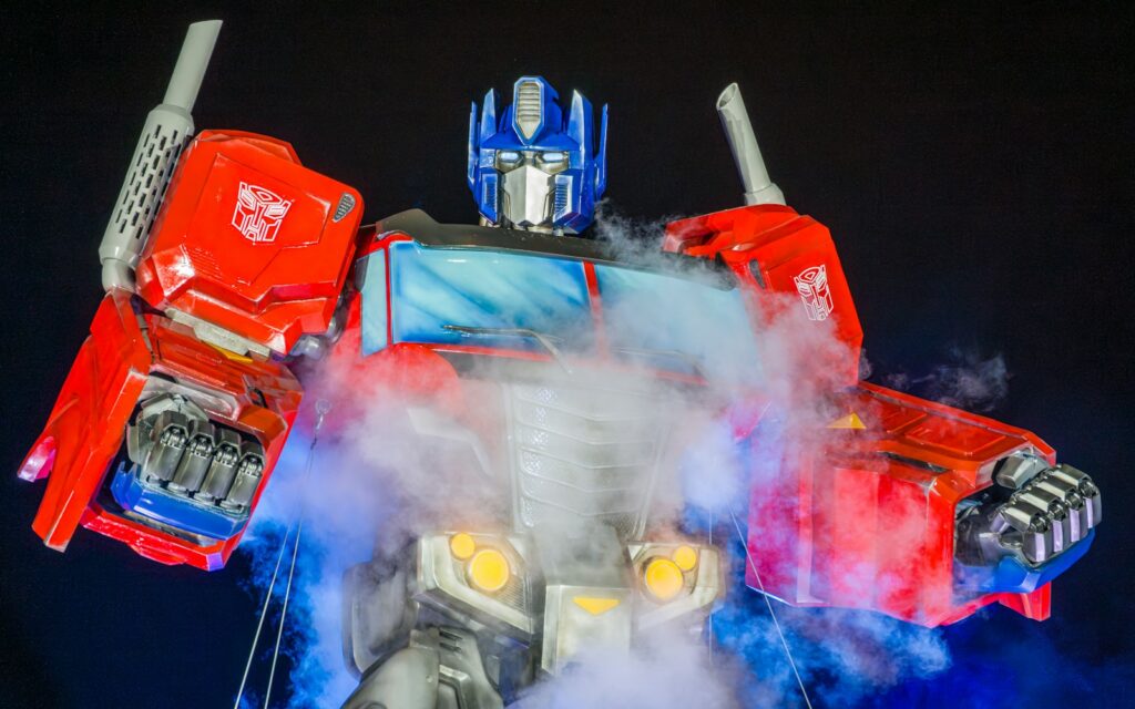 Optimus Prime toy in red and blue armor surrounded by dramatic smoke.