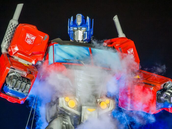 Optimus Prime toy in red and blue armor surrounded by dramatic smoke.