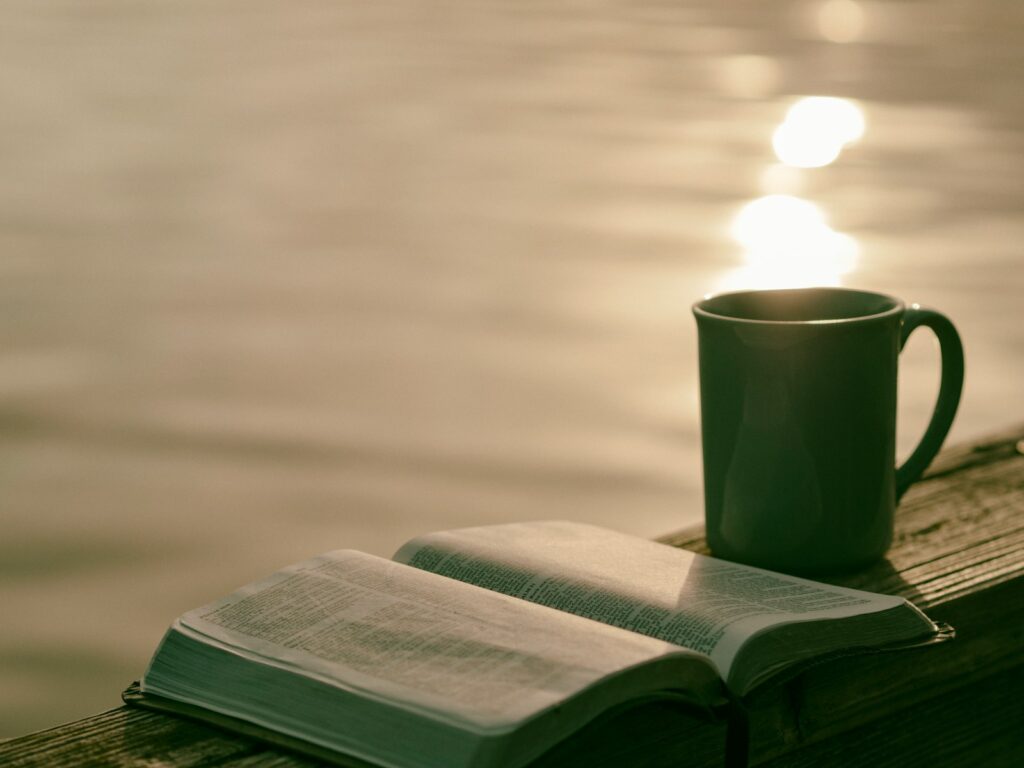 green ceramic mug beside Bible for morning bible verses to start the day
