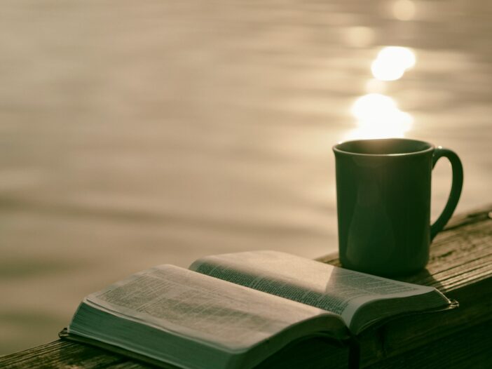 green ceramic mug beside Bible for morning bible verses to start the day