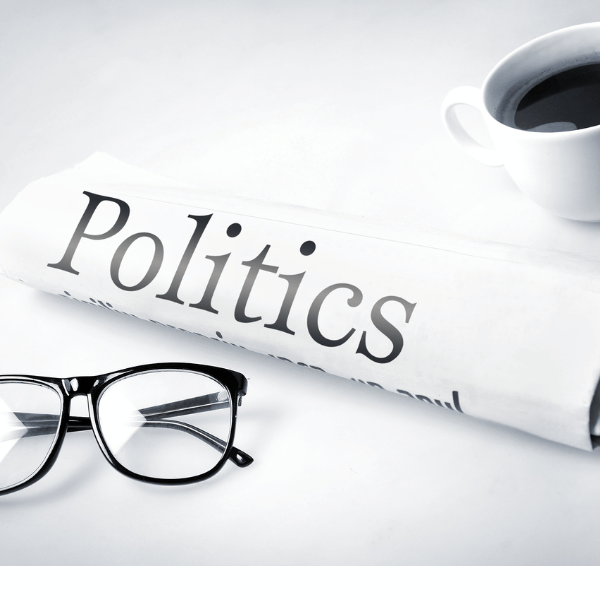Politics text on paper with glass and mug against white background