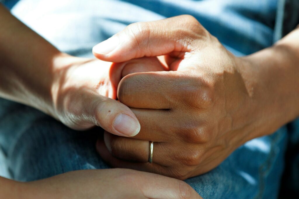 Person holding hands, illustrating words of comfort from the Bible
