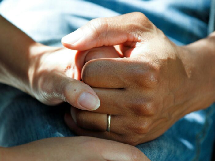 Person holding hands, illustrating words of comfort from the Bible