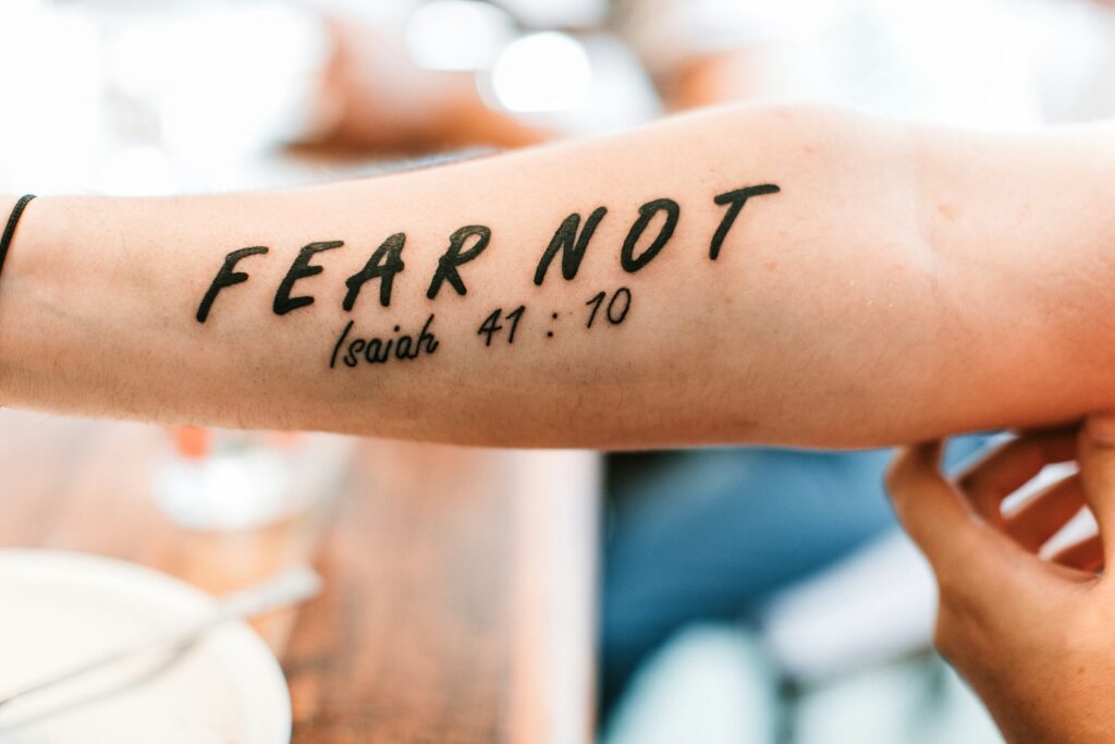 person with fear not tattoo from the Bible verse Isaiah 41:10 on arm