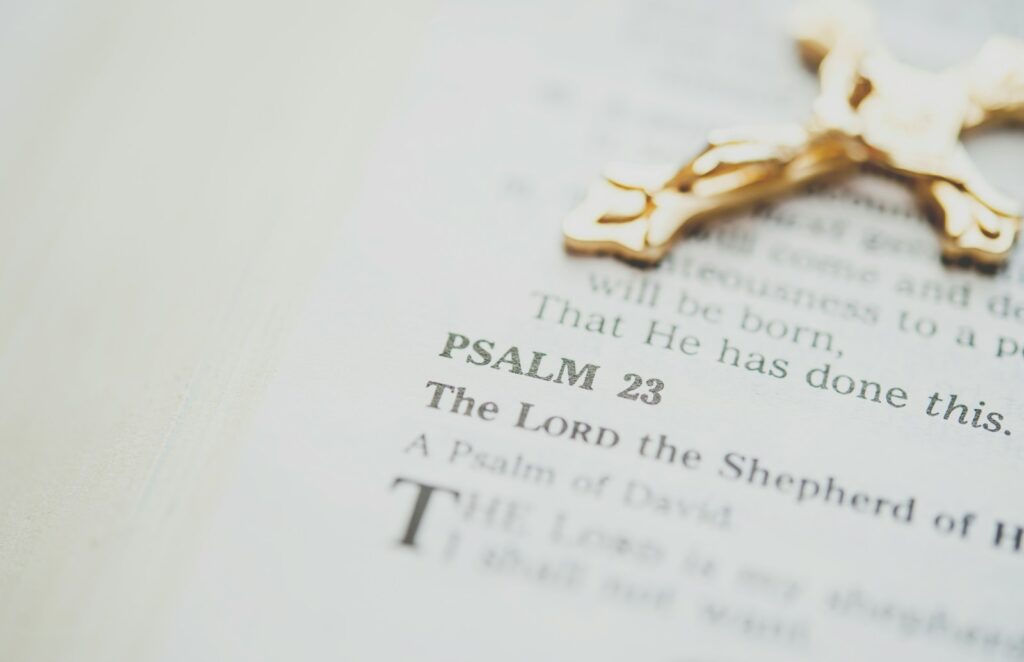 Open Bible featuring Psalm 23, one of the most powerful Bible verses with gold-colored crucifix