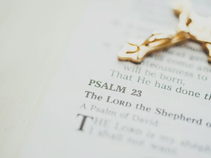 Open Bible featuring Psalm 23, one of the most powerful Bible verses with gold-colored crucifix