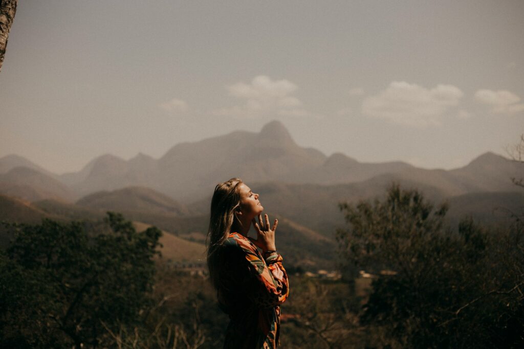 woman in black jacket standing on green grass field during daytime to represent God's mercy in the morning
