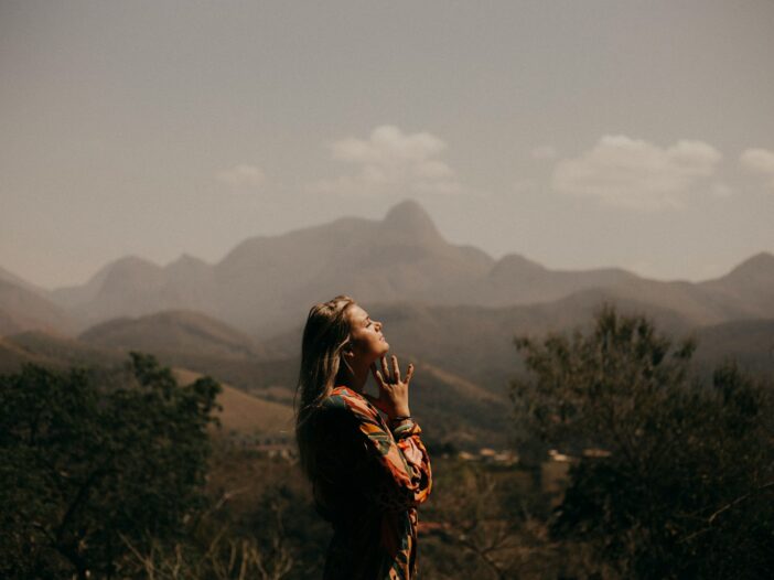 woman in black jacket standing on green grass field during daytime to represent God's mercy in the morning