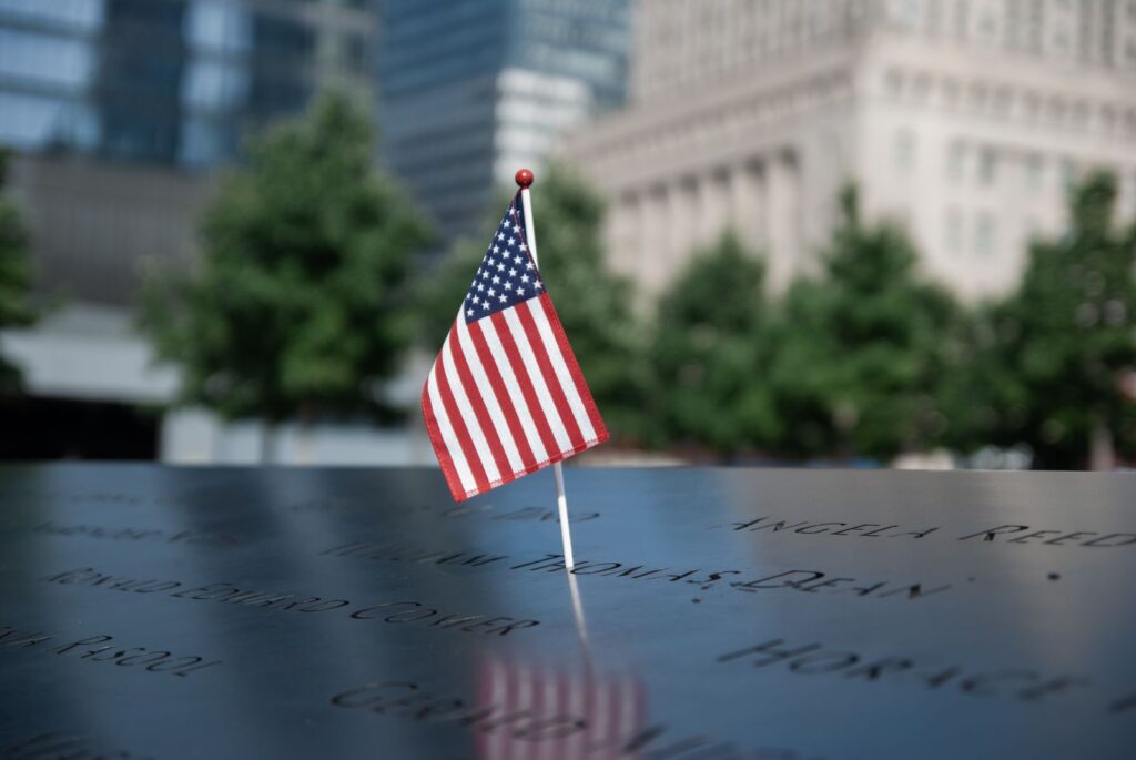 American flag at the September 11 Memorial in NYC, symbolizing remembrance and patriotism.