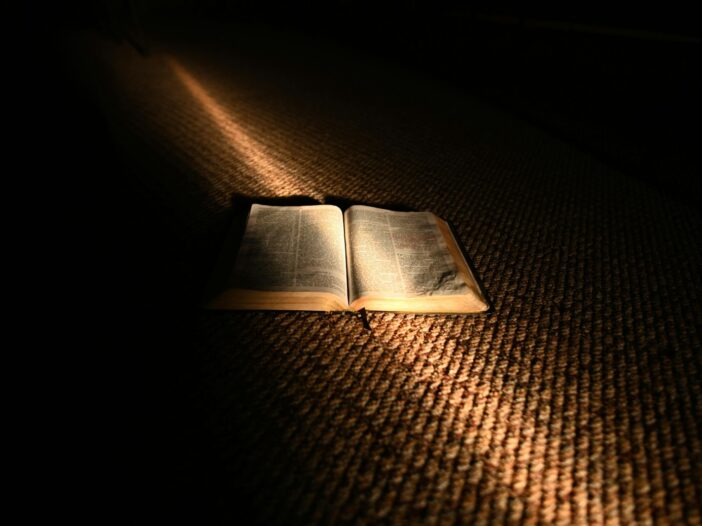 C.S. Lewis The Problem of Pain represented by an open book illuminated in darkness
