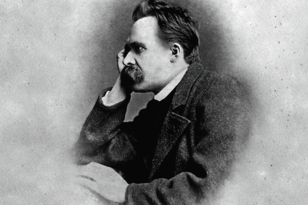 Black-and-white portrait of Friedrich Nietzsche seated with his head resting on his hand