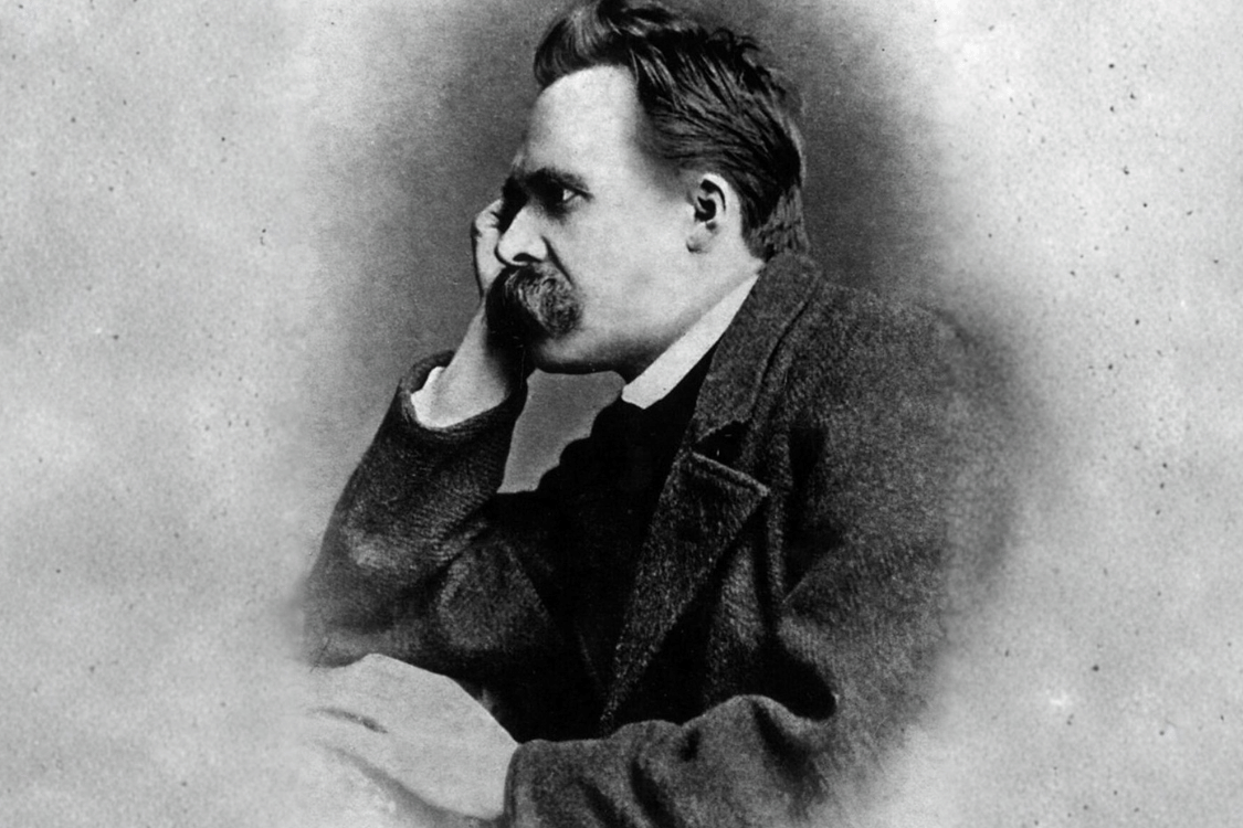 Black-and-white portrait of Friedrich Nietzsche seated with his head resting on his hand