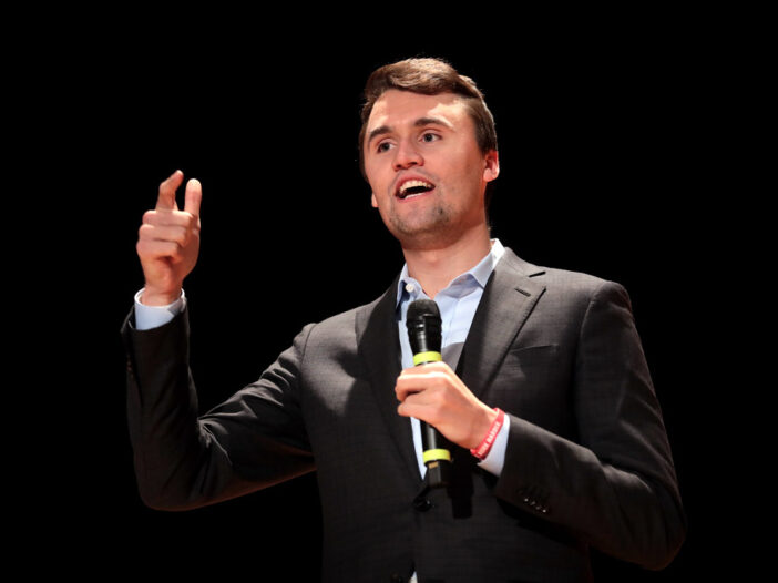 Charlie Kirk speaking into a microphone during a public event