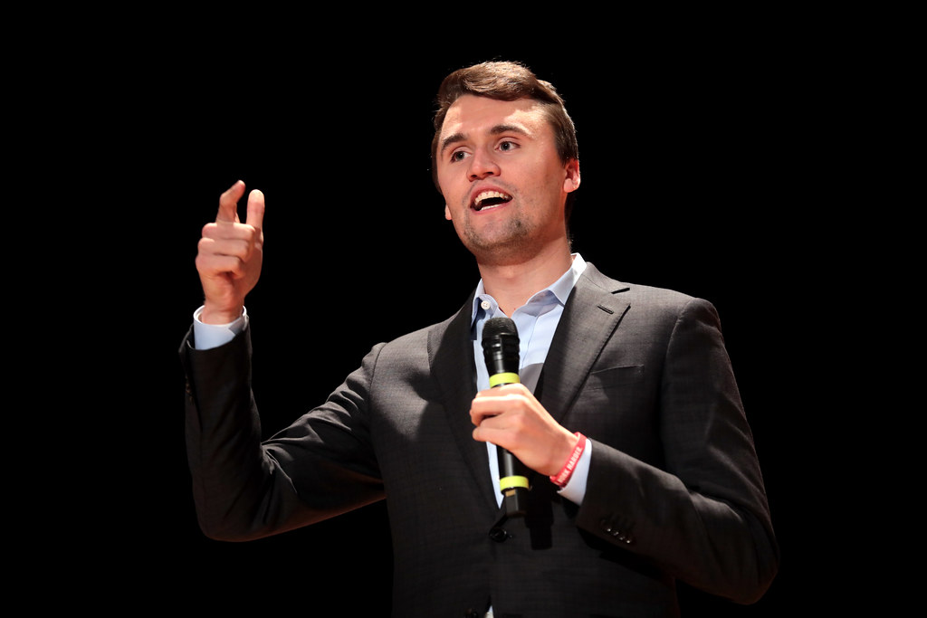 Charlie Kirk speaking into a microphone during a public event