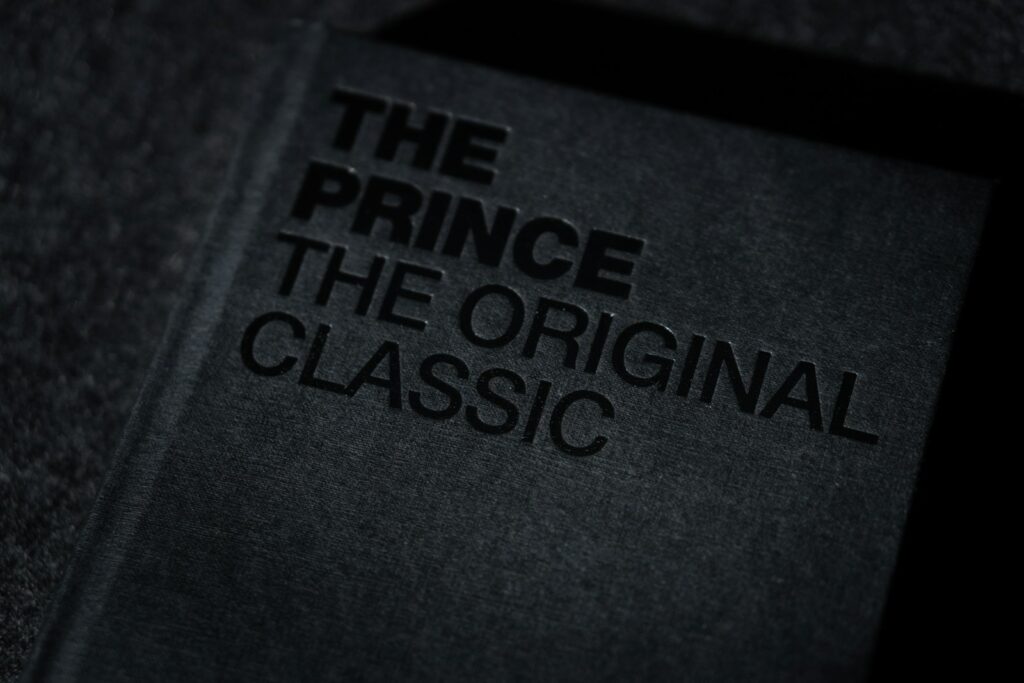 Dark-covered copy of Machiavelli’s The Prince shown in dramatic lighting