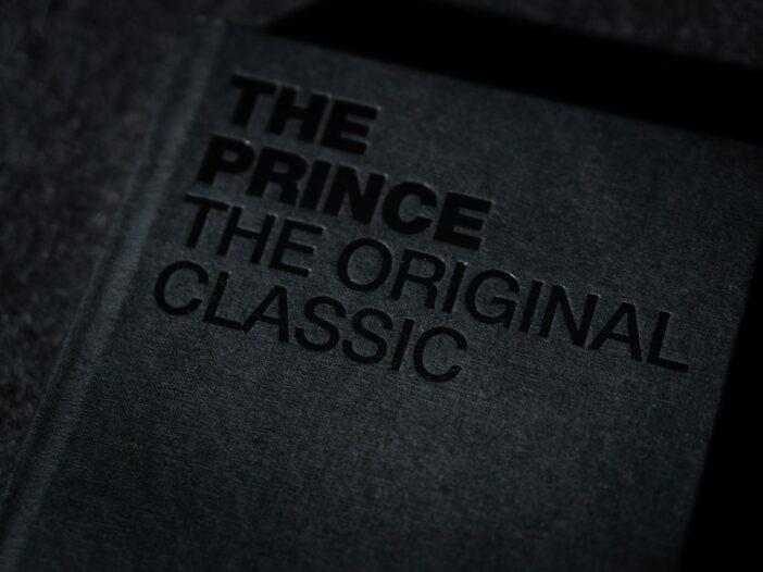 Dark-covered copy of Machiavelli’s The Prince shown in dramatic lighting