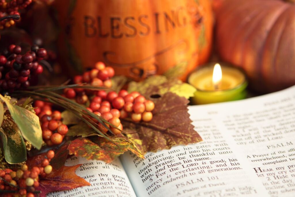Thanksgiving Bible verses beside autumn leaves, pumpkins, berries, and a glowing candle.