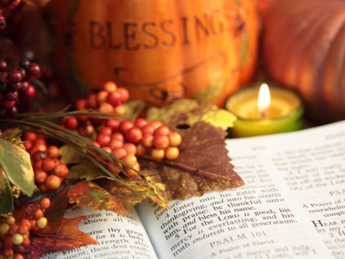 Thanksgiving Bible verses beside autumn leaves, pumpkins, berries, and a glowing candle.
