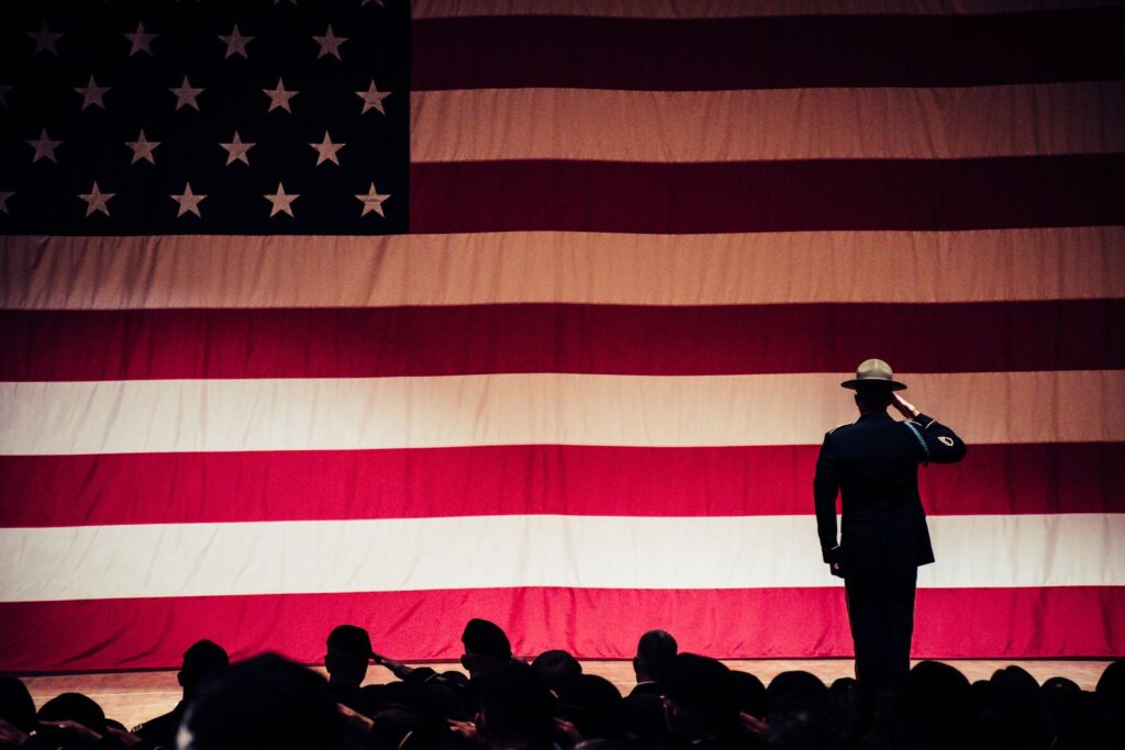 A solemn moment as a soldier salutes the American flag, illustrating inspirational Veterans day quotes to honor and thank veterans.