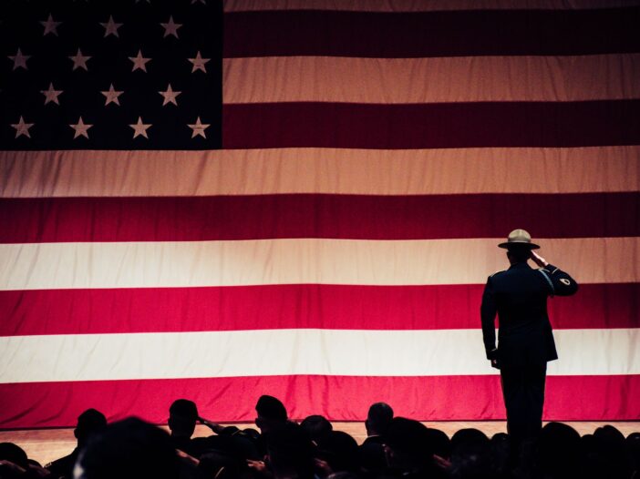 A solemn moment as a soldier salutes the American flag, illustrating inspirational Veterans day quotes to honor and thank veterans.