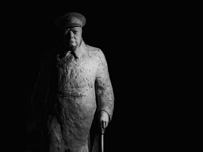 A powerful black and white photograph of a Winston Churchill statue in Paris, France.