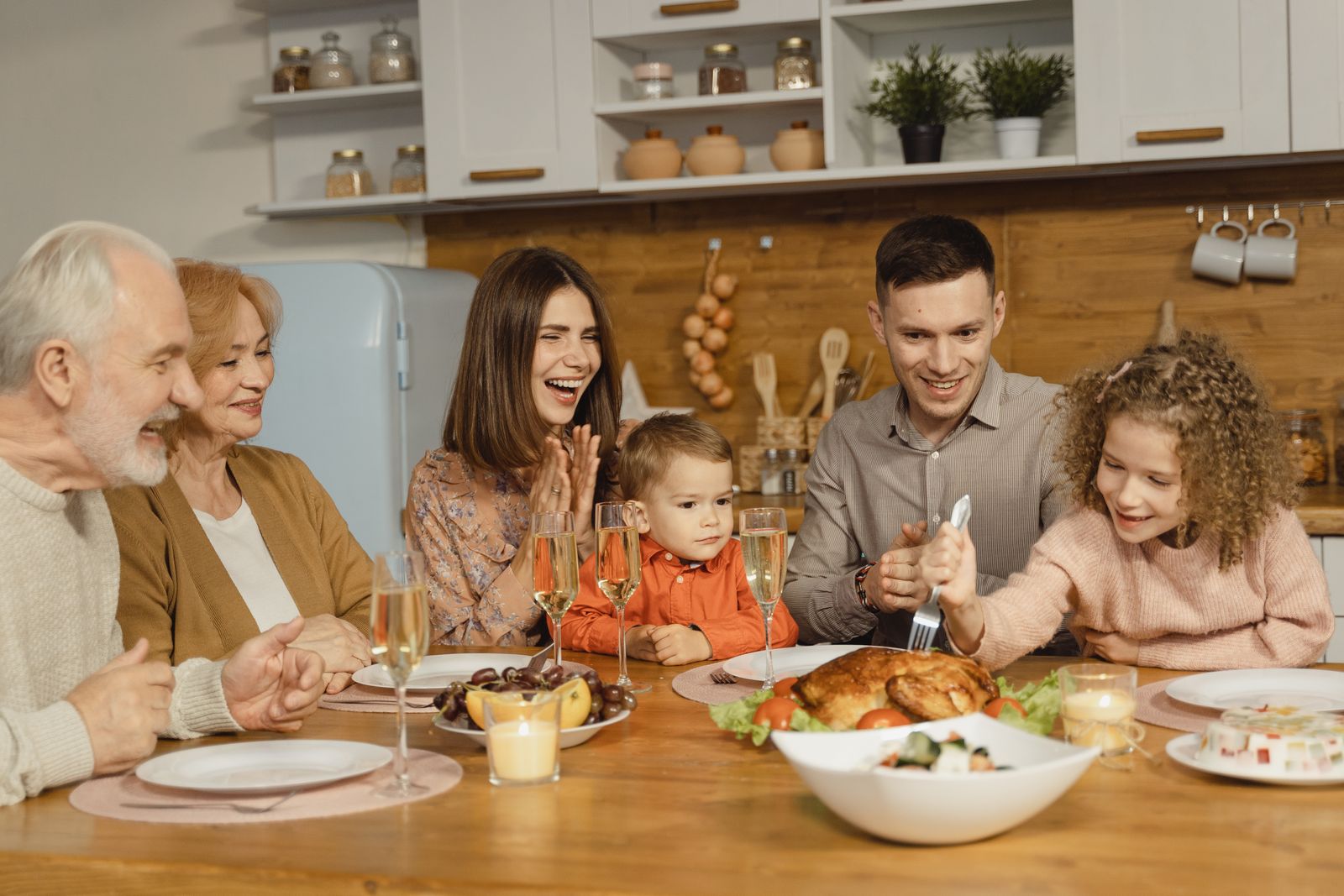 A joyful family gathering around a table for a Thanksgiving feast indoors.