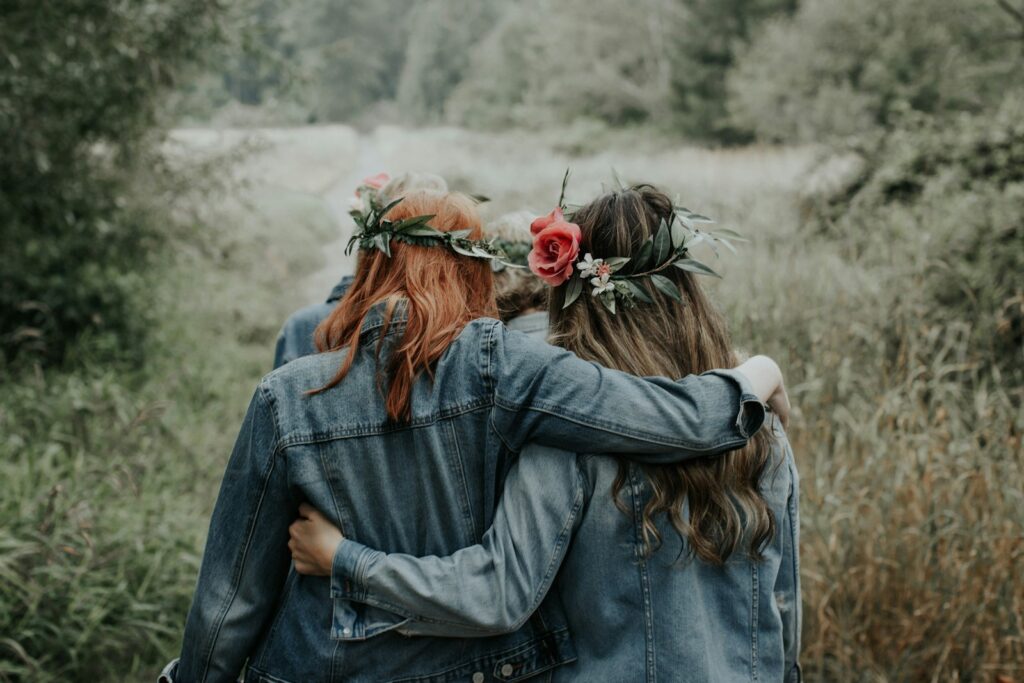 Two friends walking arm in arm outdoors, reflecting the loyal friendship described in Proverbs 17:17.