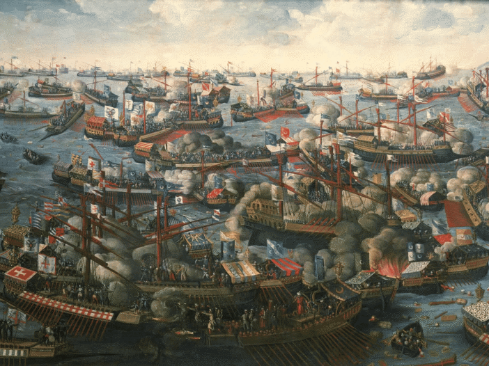 Painting of the Battle of Lepanto, with opposing galleys exchanging cannon fire across a smoke-filled sea.