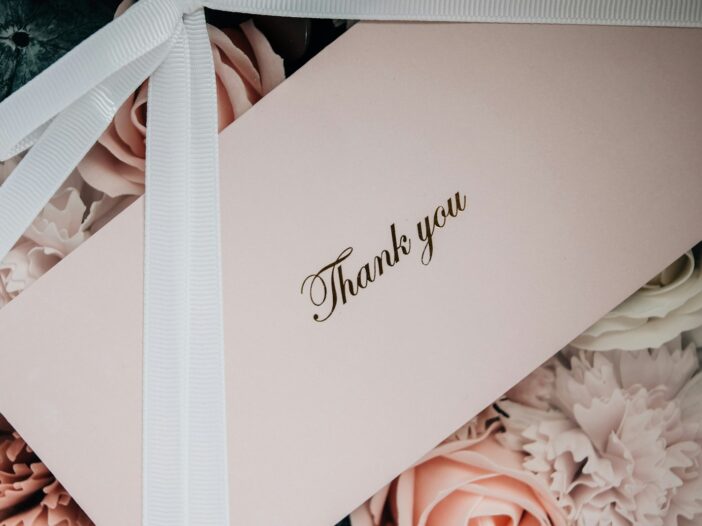 white box with white ribbon and a wedding thank you card message