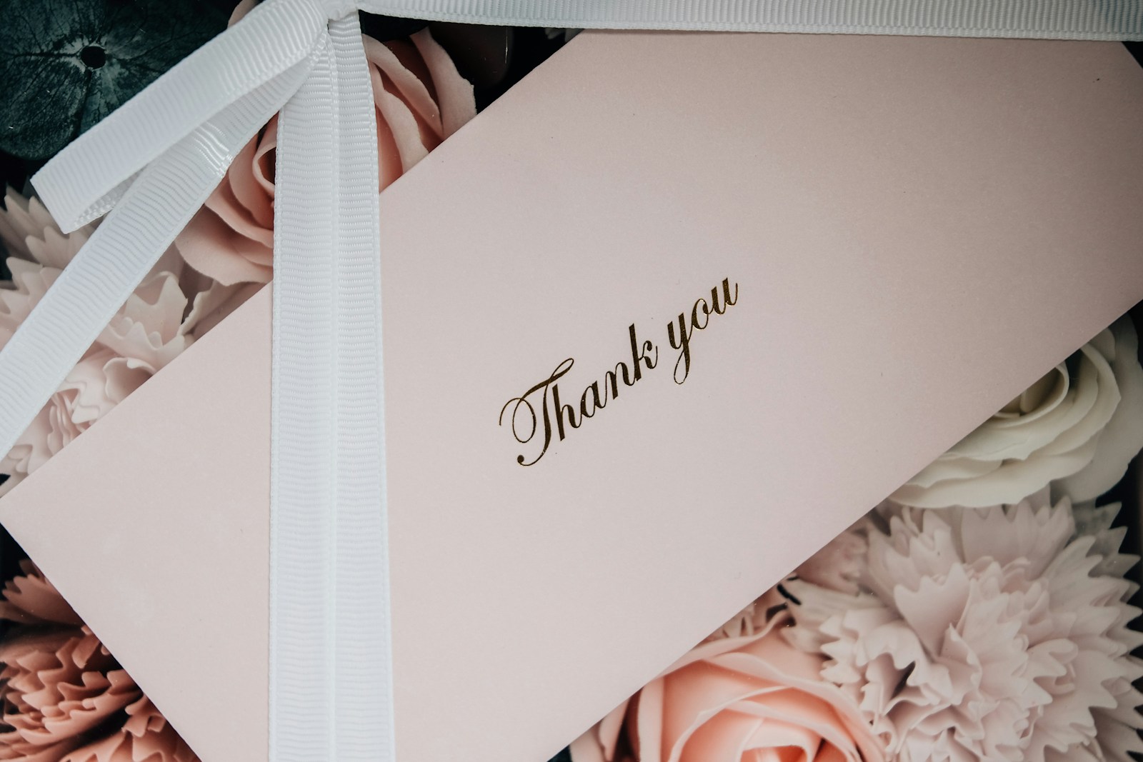 white box with white ribbon and a wedding thank you card message