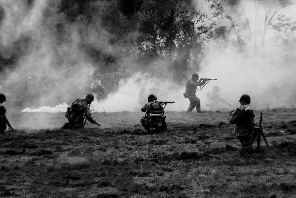 a group of men with guns in a field, illustrating a war movie scene